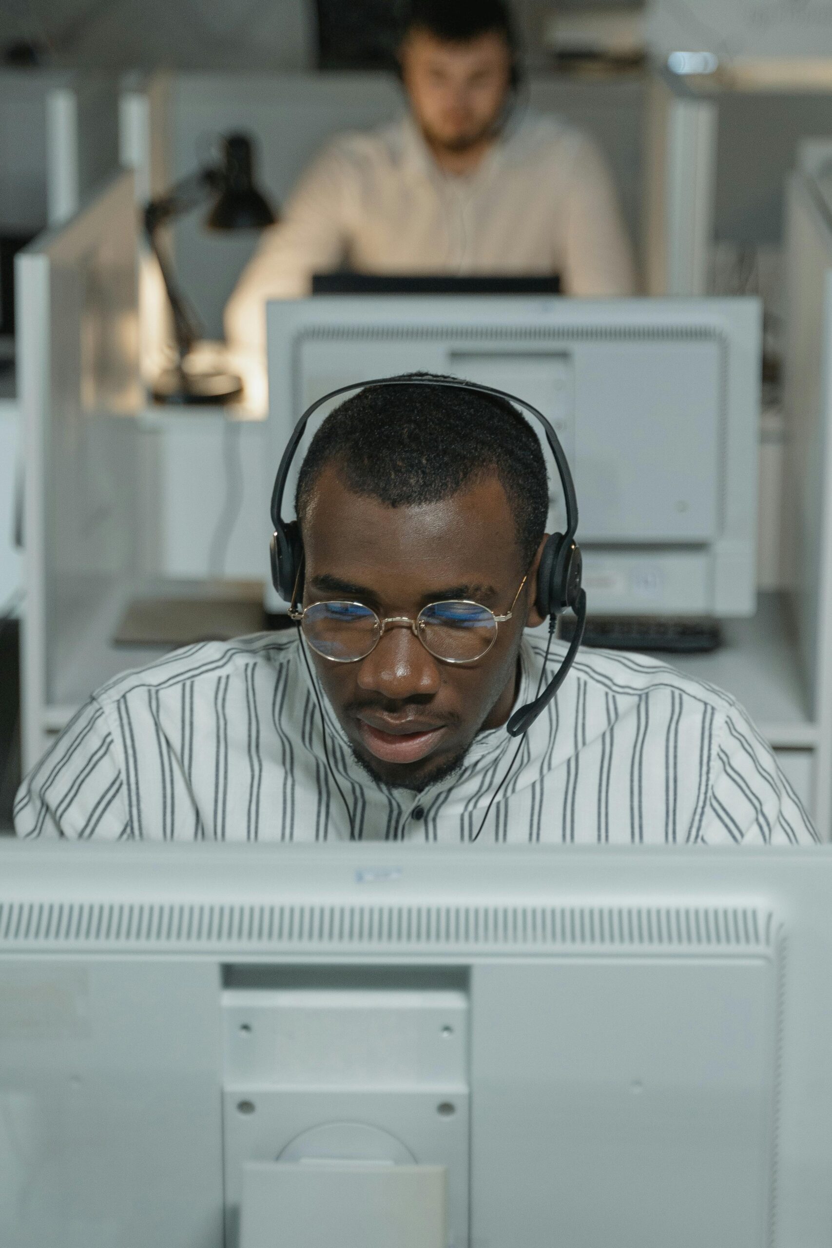 Home African American call center agent working intently with headset.